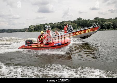 Berlin, Germany. 05th Aug, 2021. Members of the German Lifesaving Society e.V. (DLRG) demonstrate the lifeboats in Lake Pichels at a press event. Credit: Carsten Koall/dpa/Alamy Live News Stock Photo