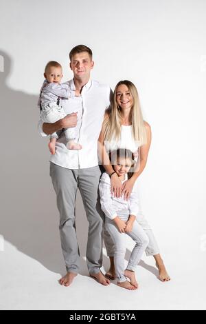 Joyful Caucasian family with two children in studio. Stock Photo
