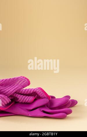 Pink microfiber cloth for washing and rubber gloves on a neutral beige background, cleaning concept Stock Photo