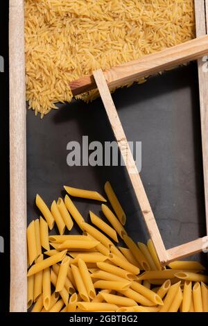 Raw pasta in asymmetrical boxes, space for text Stock Photo