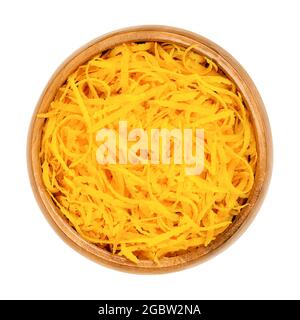Fresh organic orange zest, orange peel strips, in a wooden bowl. Skin of ripe oranges, used for baking, or dried for tea blends. Stock Photo