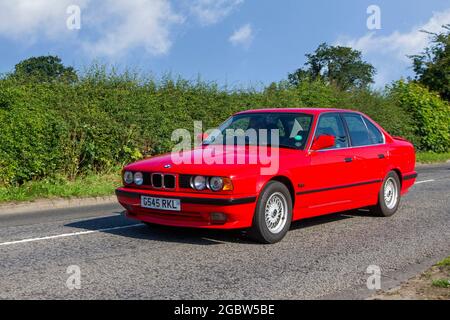 1989 80s red BMW 325i sport 5 speed manual 2494cc petrol 4dr saloon en-route to Capesthorne Hall classic July car show, Cheshire, UK Stock Photo