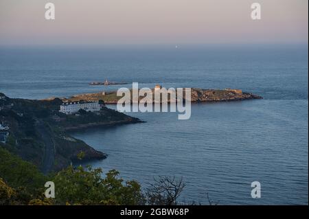 Beautiful evening view of Sorrento Point, Dalkey Island and Muglins Lighthouse from Killiney Hill during golden hour, Dublin, Ireland. Soft focus Stock Photo