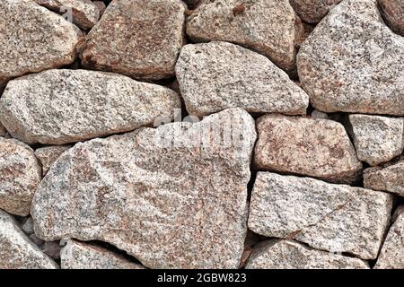 Wall with gray and brown irregular different sized and shaped stones Stock Photo