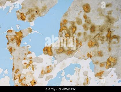 Peeling blue and brown paint on concrete wall forms abstract background Stock Photo