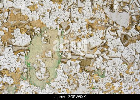 Cracked and peeling white and beige paint forms abstract background Stock Photo