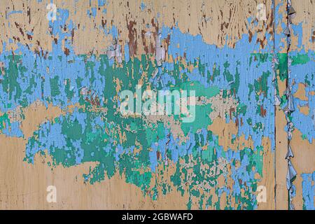 Peeling green and blue paint on wooden wall forms abstract background Stock Photo