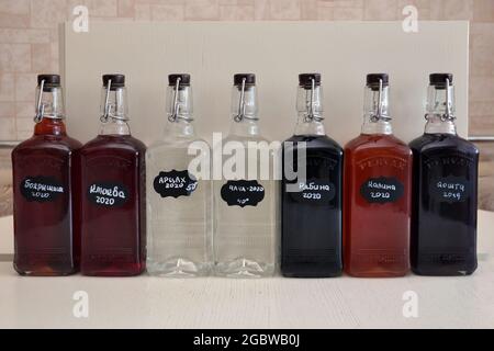 MOSCOW, RUSSIA - JANUARY 17, 2021: homemade moonshine with different flavors. Handwritten lettering in Russian Stock Photo