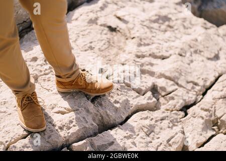Male legs in brown brogues on the rock. Close-up Stock Photo