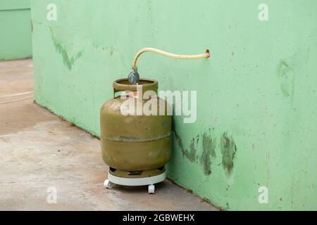 Kitchen gas canister outside the house by hole in the kitchen wall Stock Photo