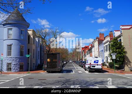 WASHINGTON, DC -2 APR 2021- View of a delivery truck from the United States Postal Service (USPS) and one from UPS (United Parcel Service) parked on t Stock Photo
