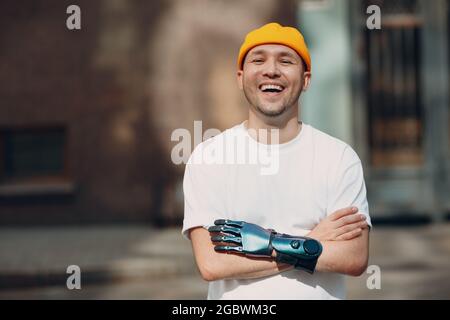 Young disabled man with artificial prosthetic hand in casual clothes laughing portrait Stock Photo