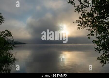 An early morning at Lac de Joux, Switzerland: Beautiful scenery with fog and the rising sun Stock Photo