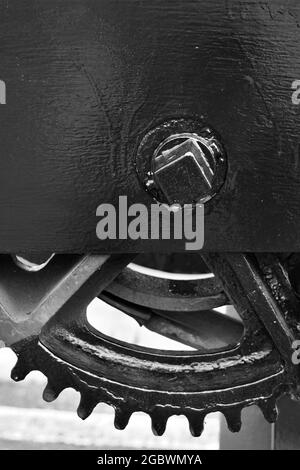 BLACK AND WHITE CLOSE-UP SHOT OF THE COGS AND WHEEL OF A DOCKSIDE WINCH Stock Photo
