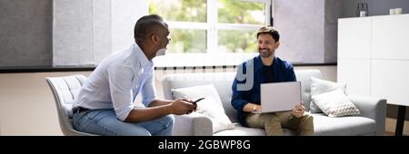 African American Person Talking To Partner Using Laptop Stock Photo