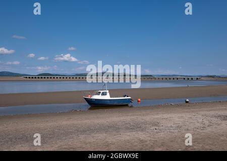 Low tide at Arnside in Lancashire, England with fishing boats high and dry infront of the busy village promenade. Stock Photo