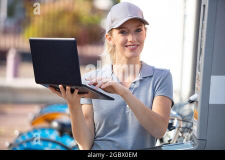 woman bicycle mechanic is repairing a bike outdoors Stock Photo