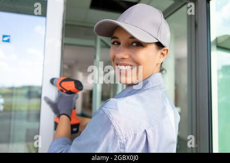 female builder using cordless electric screwdriver Stock Photo
