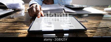E Invoice Receipt On Tablet Computer. Accountant Manager Checking Bills Stock Photo