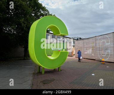 A female shopper at a welcome notice outside the shopping centre entrance, Corby, England. Stock Photo