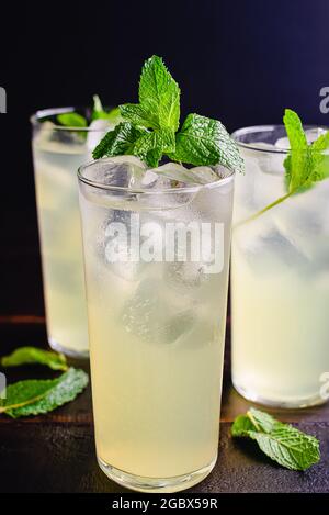 Glasses Limonata Turkish Lemonade with a Mint Garnish: Lemonade with a mint garnish on a wooden table Stock Photo