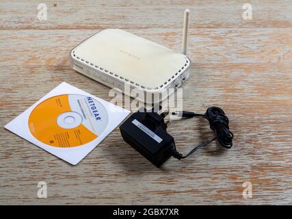 Netgear DG384G router with power supply and manual on CD Stock Photo