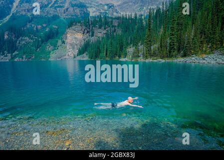 Man swimming, Lake O'Hara, Yoho National Park, British Columbia, Canada Stock Photo