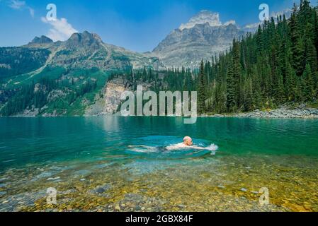 Man swimming, Lake O'Hara, Yoho National Park, British Columbia, Canada Stock Photo