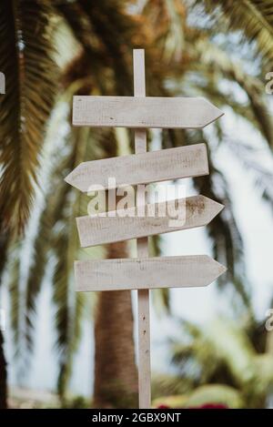 Close-up of a wooden sign in a park with several arrows indicating various directions. Stock Photo