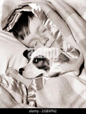 1950s BOY SLEEPING UNDER BLANKET IN BED WITH BEST FRIEND DOG - d2376 CRS001 HARS 1 JUVENILE FRIEND PILLOW BLANKET BEST BEDTIME JOY LIFESTYLE STUDIO SHOT HOME LIFE COPY SPACE PEOPLE CHILDREN FRIENDSHIP CARING MALES PETS SATIN PLAID AMERICANA SPOT B&W PARTNER PRETEEN BOY DREAMS HAPPINESS MAMMALS SLEEPY HEAD AND SHOULDERS HIGH ANGLE HIS MISCHIEF STRATEGY CANINES EXCITEMENT FORBIDDEN SNEAKING PRETEEN POOCH CUDDLING TRUSTING COMPANION COVERS CUDDLE ESCAPE BEST FRIEND MONGREL MUTT ANIMALS DOG CANINE COOPERATION GROWTH JUVENILES LOYAL LOYALTY MAMMAL NAP PRE-TEEN PRE-TEEN BOY TABOO TOGETHERNESS Stock Photo