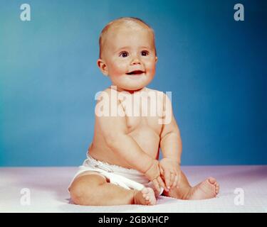 1960s PORTRAIT OF SMILING BABY GIRL SITTING UPRIGHT WEARING CLOTH DIAPER - kb5600 HAR001 HARS GROWTH JUVENILES BABY GIRL CAUCASIAN ETHNICITY HAR001 OLD FASHIONED Stock Photo