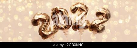 Golden numbers 2022 from New Year's balls of yellow metallic color on a background of bright bokeh from the lights. The concept of a happy and healthy
