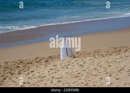 Broken surfboard left on a beach Stock Photo
