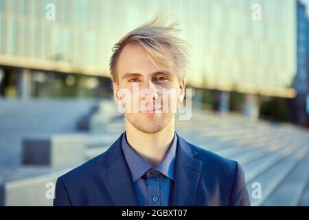 Friendly face of young businessman in front of an office building. Stock Photo