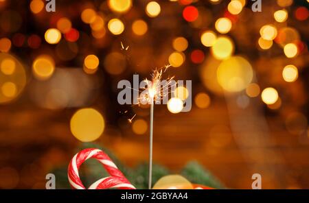 Glittering burning sparkler. Burning sparkler with bokeh background. Stock Photo