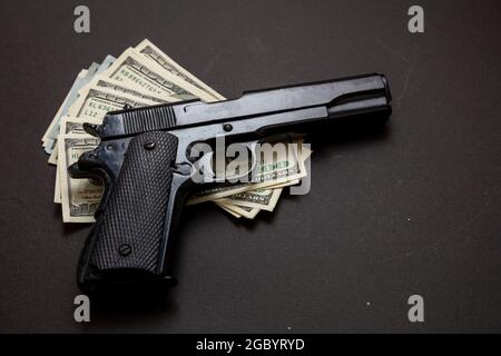 Criminal money, mafia and corruption concept, Crime concept, pistol handgun 9 mm and American dollar banknotes on black background. Stock Photo