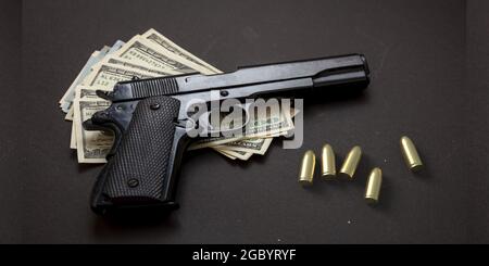 Crime concept, pistol handgun 9 mm and American dollar banknotes on black background. Criminal money, mafia and corruption concept, Stock Photo