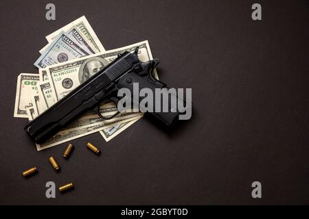 Criminal money, mafia and corruption concept, Crime concept, pistol handgun 9 mm and American dollar banknotes on black background. Stock Photo