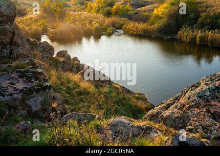 A small pile of stones in a green-yellow field against the background of sky in beautiful Ukraine Stock Photo