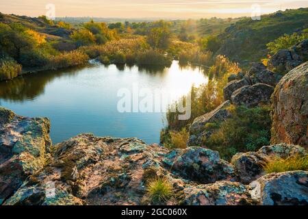 A small pile of stones in a green-yellow field against the background of sky in beautiful Ukraine Stock Photo