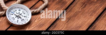 Compass and rope on wooden texture background. Stock Photo