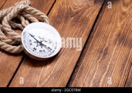 Compass and rope on wooden texture background. Stock Photo
