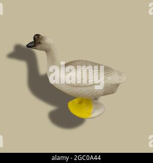 Childrens toy figurine of goose on colored background. Plastic poultry isolated against of beige background Stock Photo