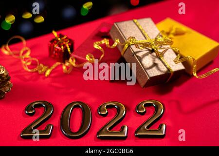 Beautiful New Year photo with figures 2022 and gifts with ribbons with a side in the background. Year of the tiger, layout, magic card Stock Photo