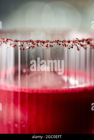 Alcoholic beetroot cocktail beverage in elegant glass on wooden table. Stock Photo