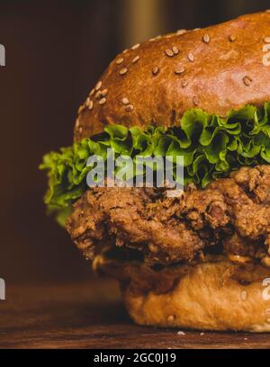 Hamburgers with fried chicken and salad. Sandwich with lettuce, tomato, onion, avocado, cucumber and chicken. Commercial use burger with green salads. Stock Photo