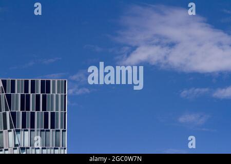Abstract image of a modern glass office building in Tokyo with blue sky and light cloud. Japan. Stock Photo