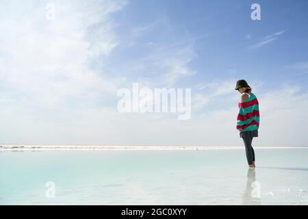 asian woman standing in a salt lake looking down at the water Stock Photo