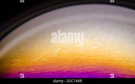 Macro of colorful iridescent soap bubble with abstract patterns and shapes, futuristic space art wallpaper or background Stock Photo