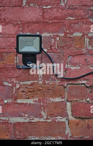 Light with automatic motion sensor on a red brick wall. Stock Photo
